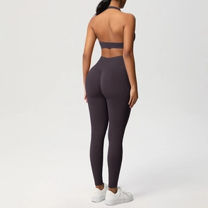Dettaglio dei leggings yoga a vita alta e reggiseno allacciato al collo in viola scuro