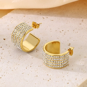 Detailed shot of gold C-shaped earrings with five rows of pavé crystals on stone base