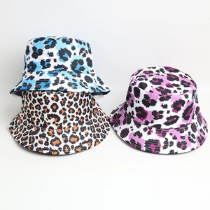 Leopard print bucket hats in blue, brown, and purple colors on a clean grey background