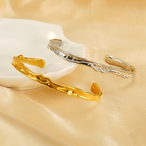 Bracciale rigido con trama lavica irregolare in oro e argento su sfondo di seta