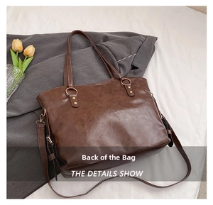 Detailed back view of a dark brown large oil wax leather tote bag with gold metal rings