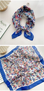 Detail of floral linen-cotton square scarf with blue border and elegant knot styling