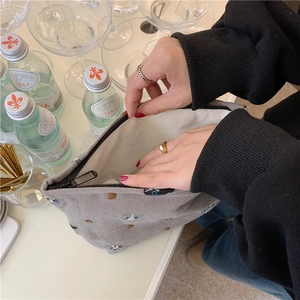 Close-up of cute cat embroidery on canvas makeup pouch with open zipper compartment