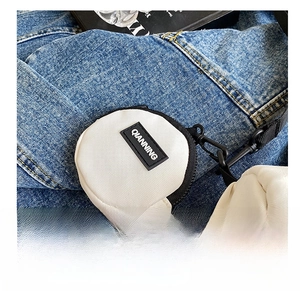 Close-up of a white canvas round coin purse with black zipper and QIANNING logo tag