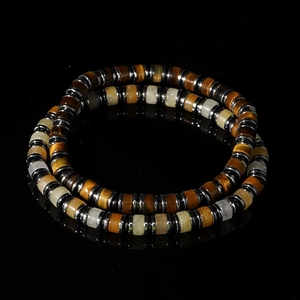 Tiger eye and stone beaded bracelet with silver spacers on a sleek black background