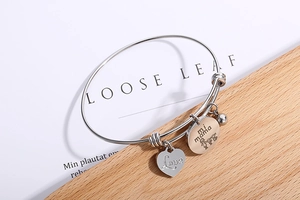 Detailed close-up of adjustable silver heart bracelet engraved with Love and mi mama