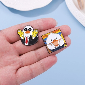 Cartoon enamel duck pins featuring secret agent and art parody designs in hand