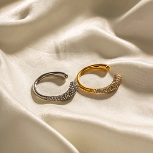 Elegant gold and silver C-shaped ear cuffs with sparkling crystals on white silk