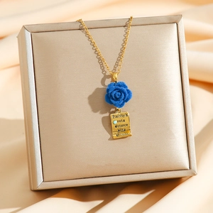 Velvet rose pendant necklace with gold square engraved tag on elegant silk background