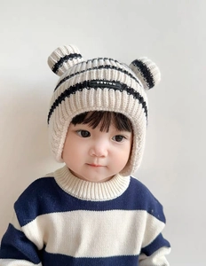 Detail of baby knit hat with 3D ears, striped sweater, and soft ear protection design