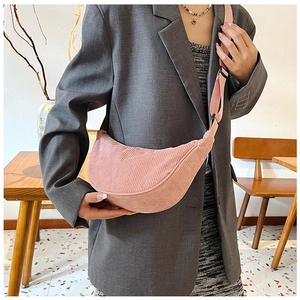 Detail view of pink corduroy crescent crossbody bag with adjustable strap and casual style