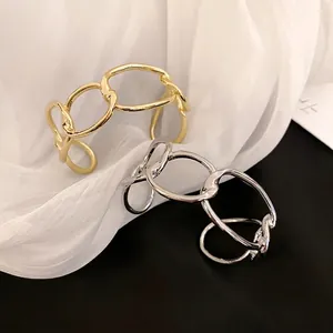 Minimalist thick chain open bangles in gold and silver finish on white silk background