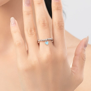 S925 sterling silver beaded ring with blue enamel heart charm on model's finger