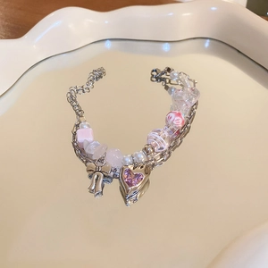 Double-layered beaded bracelet featuring pink heart zircon and silver bow pendant details