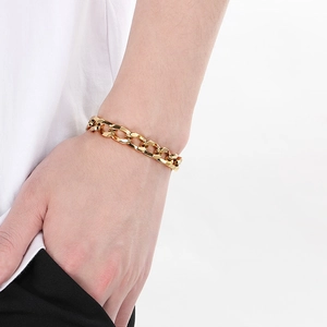 Détail d'un bracelet gourmette en acier titane plaqué or 18 carats porté au poignet