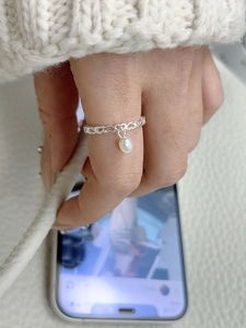 Close-up of S925 silver hollow heart ring with dangling freshwater pearl charm