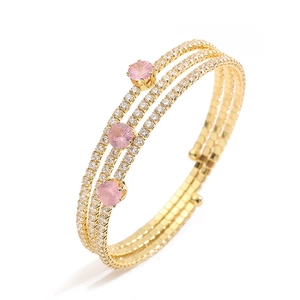 Detail of three-row gold cuff bracelet with clear pavé stones and round pink crystals