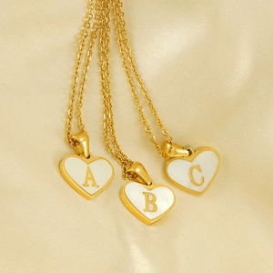 Gold heart initial necklace with white shell inlay featuring letters A B and C