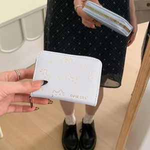 Light blue PU leather cat wallet with gold print held in a lifestyle mirror selfie