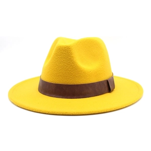 Detail of a yellow wool fedora hat featuring a brown leather band on white background