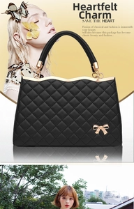 Détail d'un sac à main noir matelassé avec boucle nœud doré et bordure en métal ondulé