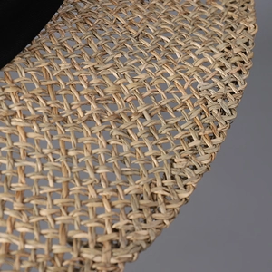 Close-up of the woven straw texture and black fabric band on this summer beach sun hat