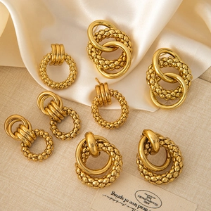 Macro detail of 18K gold-plated stainless steel hoop earrings with beaded texture