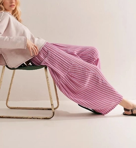 Detail of pink striped wide-leg trousers with cotton linen texture and layered design