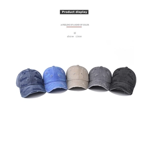 Multiple colors of washed denim baseball caps featuring vintage distressed holes and kindness embroidery