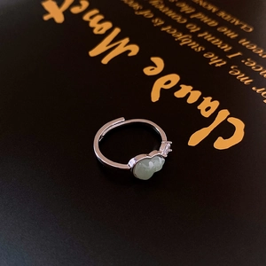 Macro shot of silver open ring with light green jade stone and sparkling zircon detail