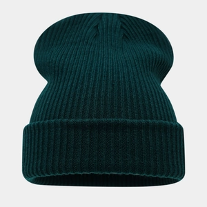 Gros plan du bonnet en maille côtelée vert foncé montrant la texture et le revers épais