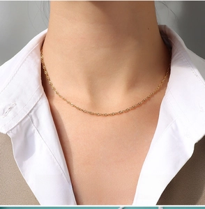 Detail of 1.9mm gold water wave chain necklace showing delicate spiral texture on skin