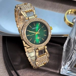 Gros plan sur la montre Grealy dorée avec cadran vert et lunette sertie de diamants