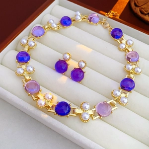 Parure de bijoux vintage avec pierres mauves et perles dans un écrin en velours