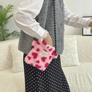 Detail of pink faux fur crossbody bag with heart patterns and sozakka beauté label