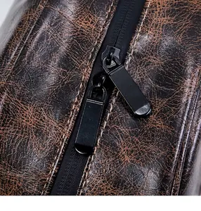 Dettaglio della doppia cerniera in metallo su borsa da toilette marrone vintage