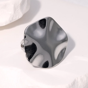 Macro view of silver irregular wavy stainless steel ring with liquid metal texture
