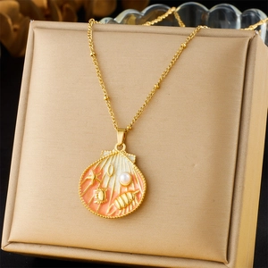 Detail of gold shell pendant with pink enamel and sea life charms on a beaded chain