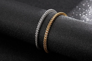 Detailed close-up of wheat braided stainless steel bracelets in gold and silver finish