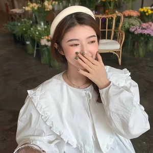 Close-up of a thick milk tea colored padded headband worn by a model in soft lighting