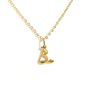 Close-up of golden stainless steel necklace with letter B pendant and heart detail