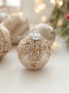 Close-up of champagne satin Christmas ball with gold sequins and white beads