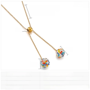Detailed view of a gold Y-shaped stainless steel necklace with sparkling rhinestone spheres