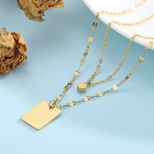 Close-up of double-layer gold necklace featuring square and round geometric pendants