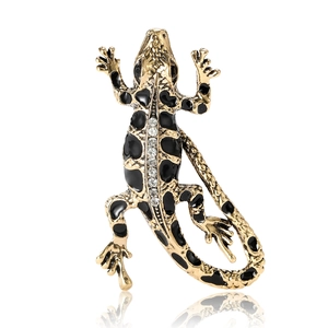 Golden lizard brooch with black enamel and sparkling rhinestones on white background