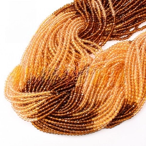 Close-up of 3mm faceted natural stone beads in amber and brown gradients for DIY jewelry