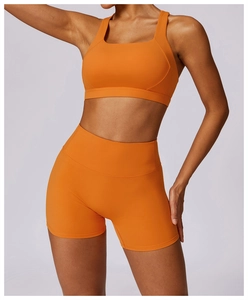 Detail of square neck yoga bra and high waist shorts in vibrant orange elastic fabric