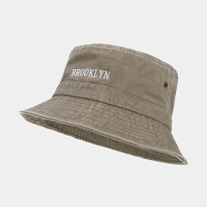 Détail de la broderie Brooklyn et œillets métalliques sur chapeau bob en toile délavée
