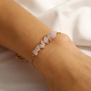 Detail of pink rose quartz natural stone bracelet with adjustable gold chain on wrist