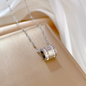 Macro detail of silver cylinder pendant with cubic zirconia and Roman numerals on fine chain